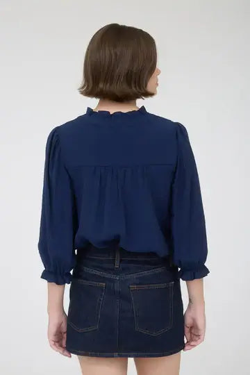 Blusa de manga 3/4 tres botones al frente con ribete y vuelo en el cuello